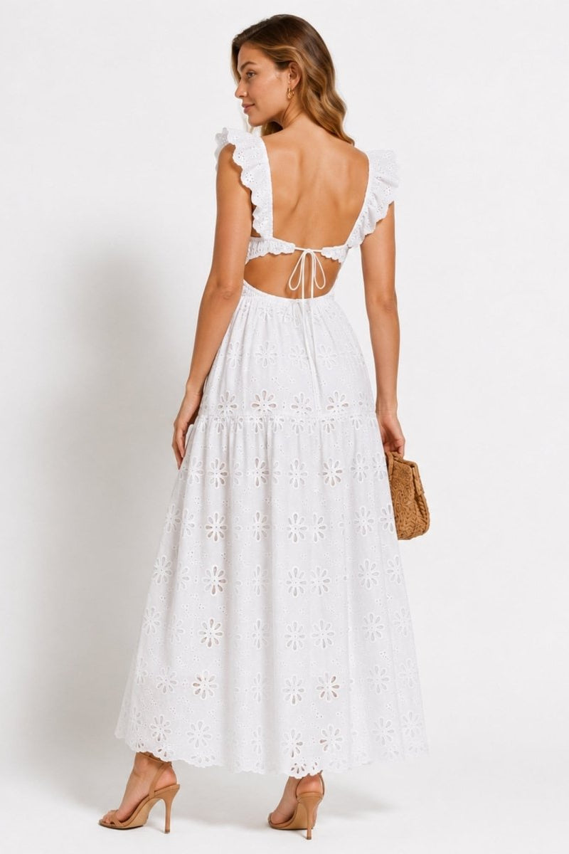 Back view of Kouvr white luxury resort wear dress featuring a cutout open tie-back design and sweeping tiered eyelet lace skirt.