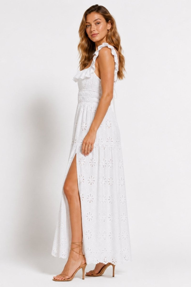 Side profile view of white broderie anglaise summer maxi dress showing smocked bodice waistline and elegant high leg slit styling.
