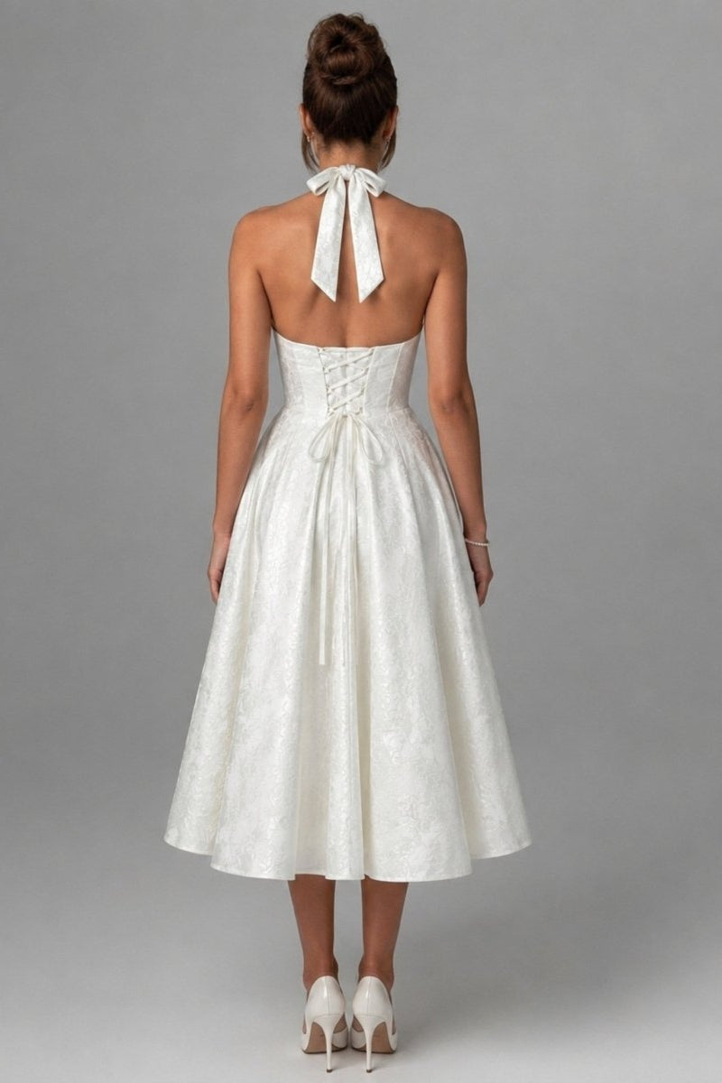 Back view of the Kouvr white bridal rehearsal dress highlighting the adjustable lace-up corset back and elegant halter tie bow.