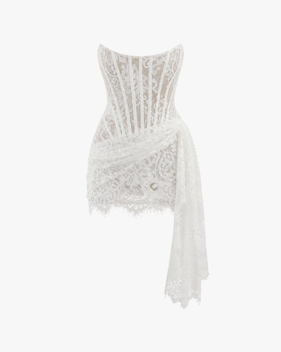 White lace asymmetrical mini dress with a corset-style bodice and draped side detail, shown on a plain white background.