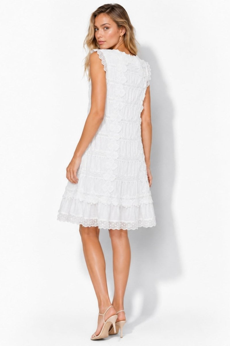 Back view of woman wearing Kouvr white romantic summer dress with scalloped hem