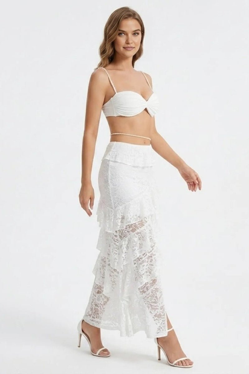 Woman wearing a white lace outfit on a plain background