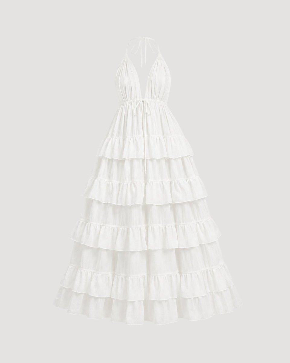 A white halter-neck maxi dress with a tiered ruffled skirt, shown against a solid light gray background.