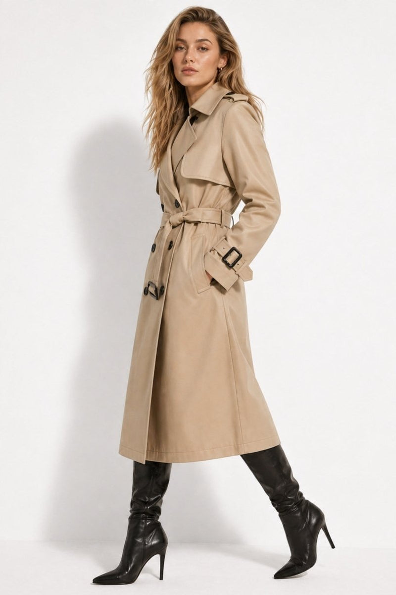 Side profile of a woman walking in a structured midi-length khaki trench coat and black leather boots