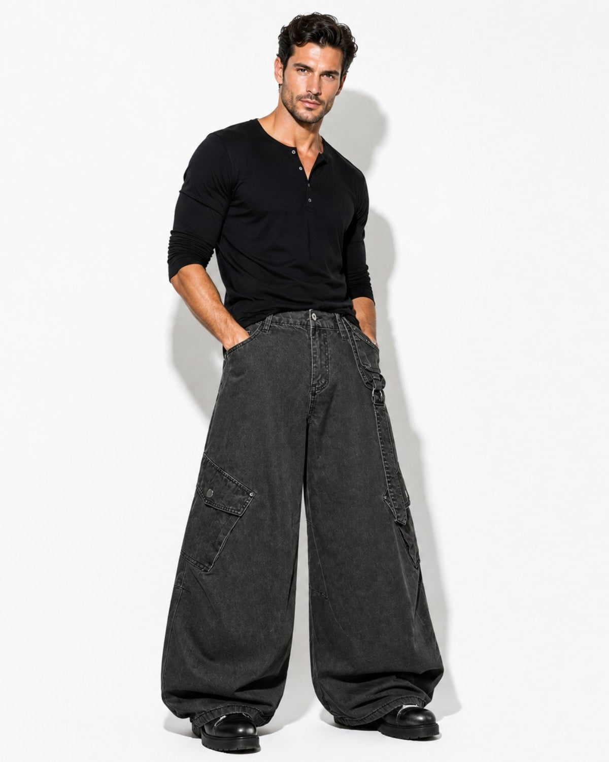 A man modeling a black long-sleeve henley shirt and wide-leg charcoal gray cargo pants against a plain white studio background.