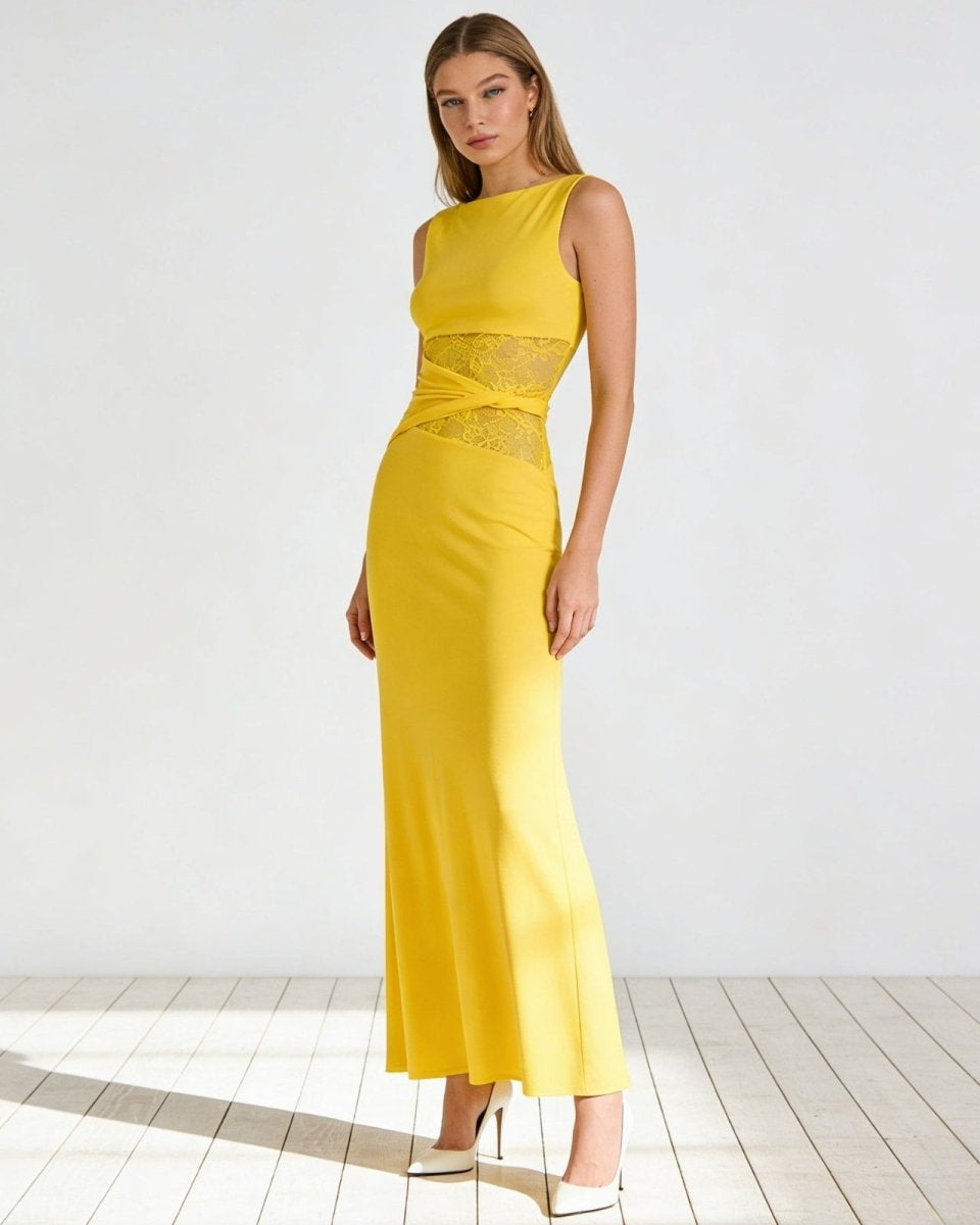 Model wearing the Deborah sleeveless yellow cut out midi dress with sheer lace waist panels, paired with red heels, on a white background.
