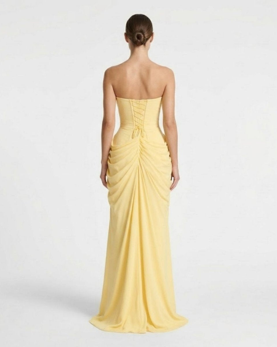 Back view of yellow maxi dress featuring adjustable lace-up corset back and soft draped flowing skirt.