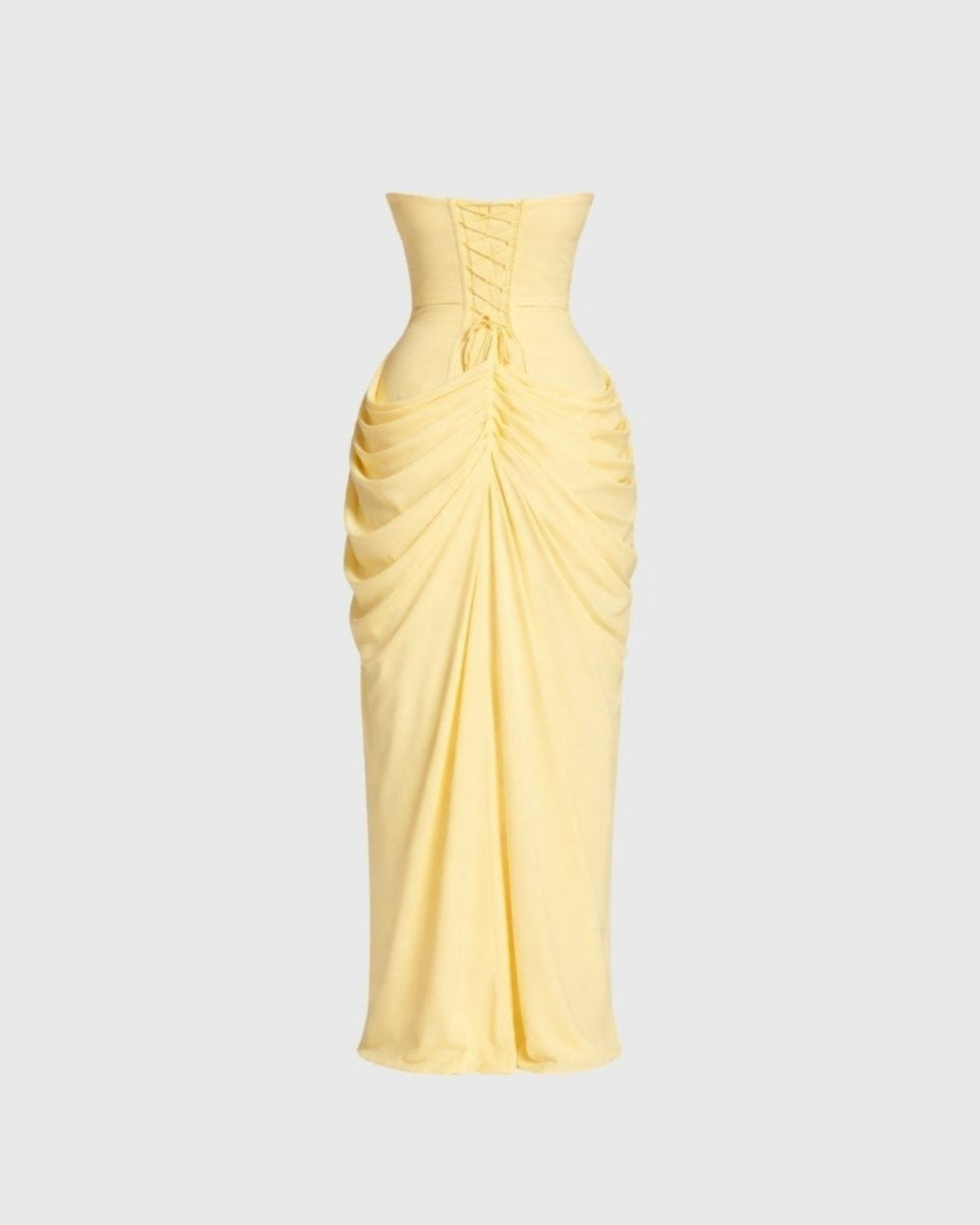 Back flat lay studio view of pale yellow formal dress highlighting the adjustable lace-up corset tie detail.