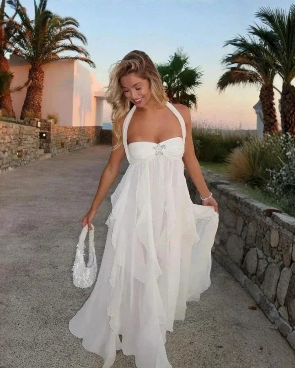 Woman in a white dress walking on a path with palm trees in the background