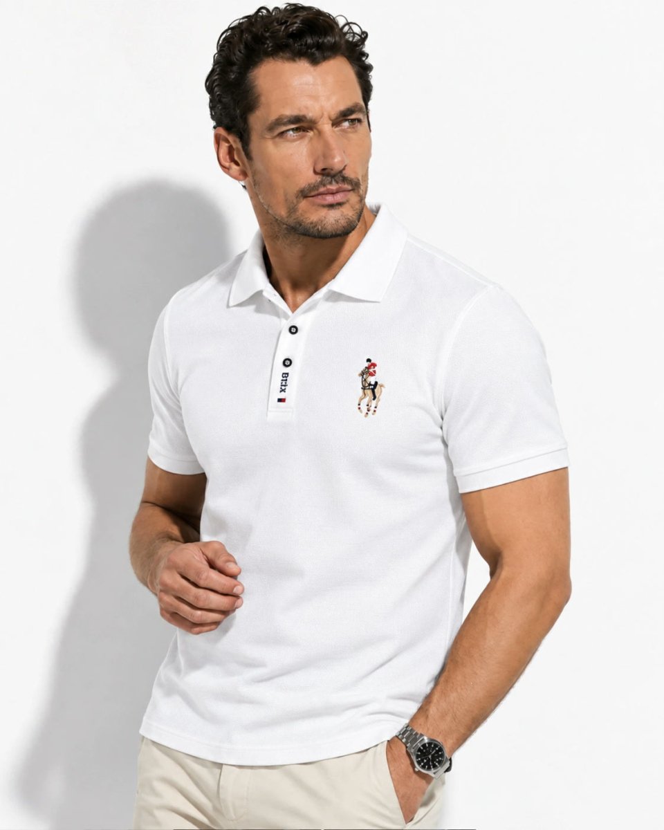 Brix: Model im hellen Poloshirt mit Brustmotiv und kurzer Knopfleiste vor hellem Hintergrund.