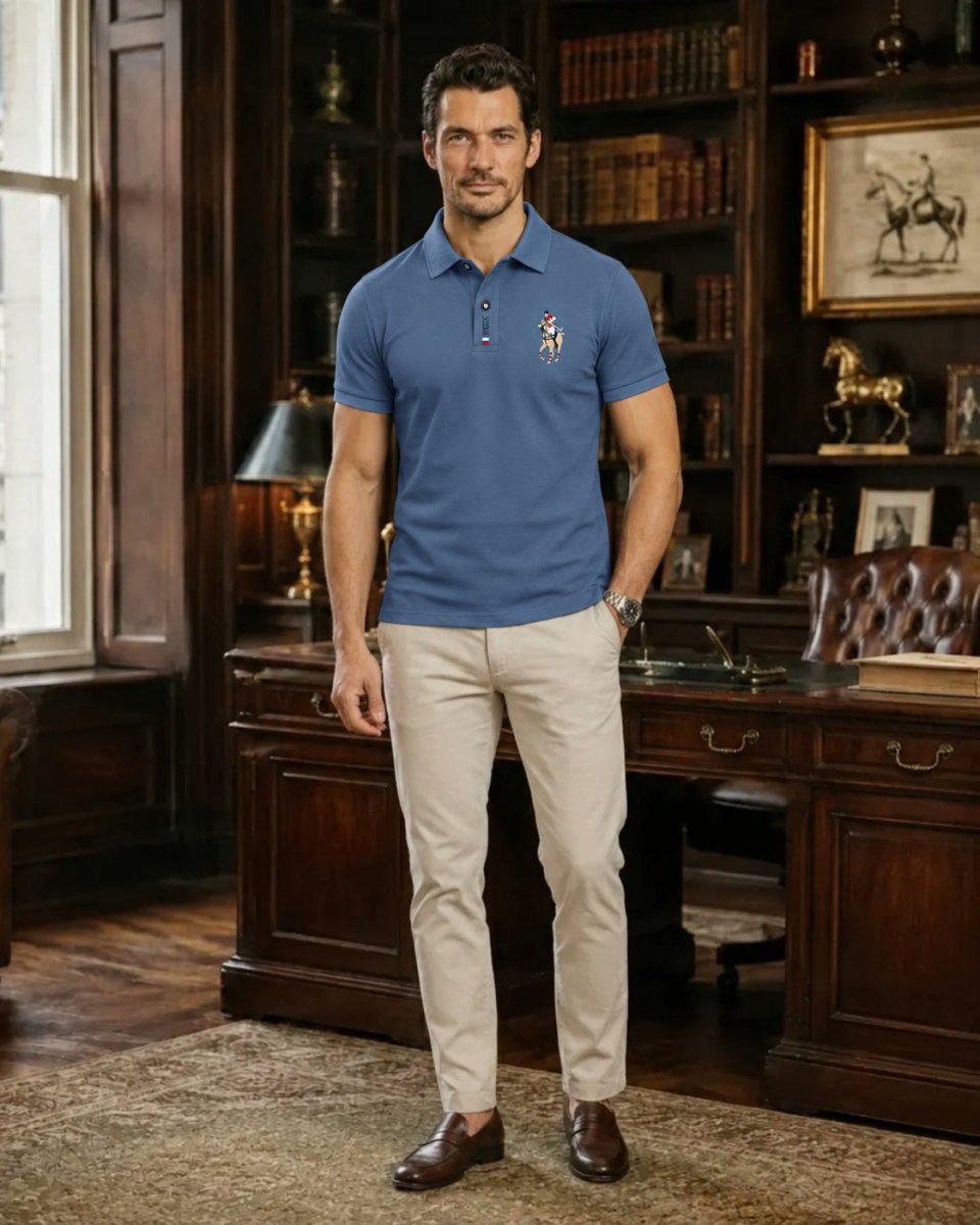 Brix: Model trägt ein blaues Poloshirt zur hellen Hose in einem Raum mit Bücherregalen.
