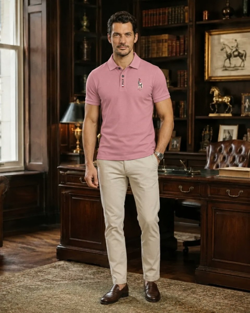 Brix: Model trägt ein rosafarbenes Poloshirt zur hellen Hose in einem Raum mit Bücherregalen.