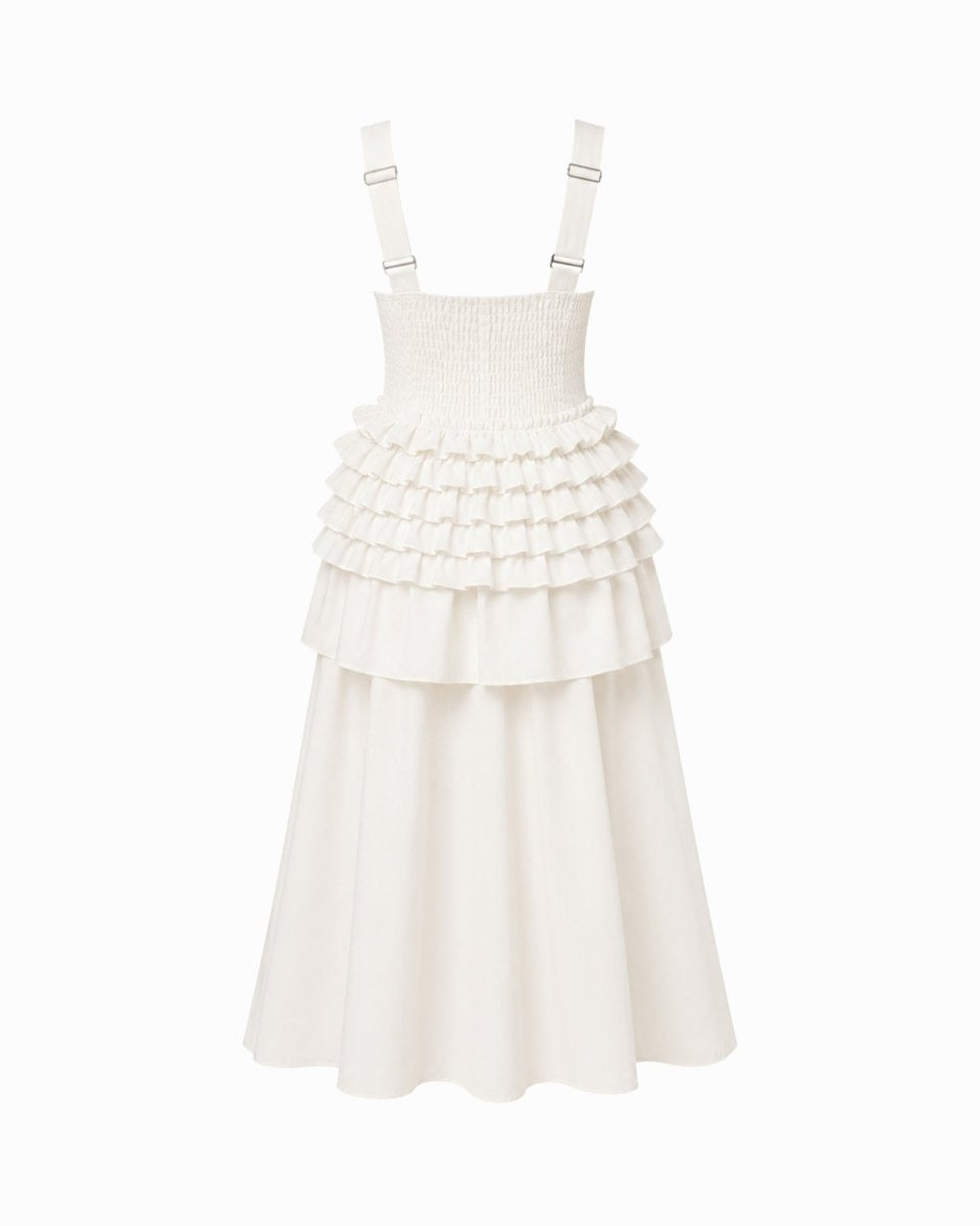 An off-white sleeveless dress with adjustable shoulder straps, a smocked bodice, and a tiered ruffle skirt, shown against a plain white background.