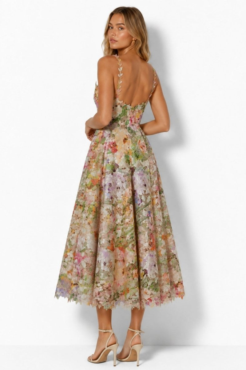Back view of model wearing Fenlo Form floral lace cocktail dress showing low back, thin straps, and full skirt.