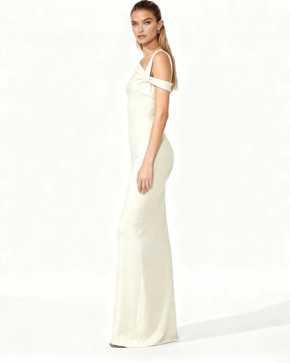 Woman wearing a long, off-shoulder cream dress on a white background