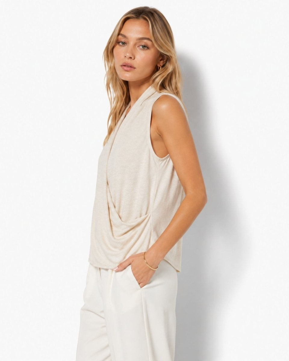 Side view of an elegant beige knit halter top demonstrating the architectural draped front styling, gathered waist detail, and relaxed fit by Fenlo Form