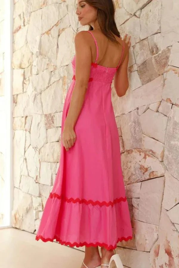 Model wearing the Kouvr Amillia pink scalloped maxi dress in front of a stone wall
