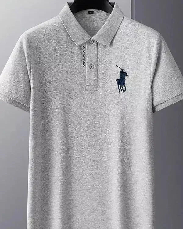Gray polo shirt with a brand logo on a hanger against a gray background