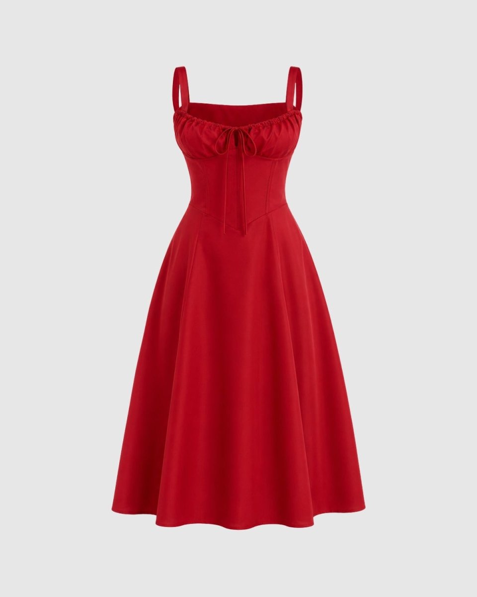 A red sleeveless swing dress with thin shoulder straps, a sweetheart neckline, a gathered corset-style bodice with a front bow, and a flared skirt, shown on a light gray background.