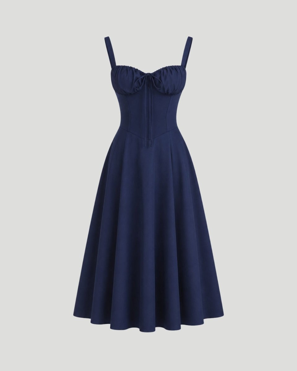 A navy blue swing dress with spaghetti straps, a sweetheart neckline, and a gathered corset-style bodice, shown against a solid light gray background.