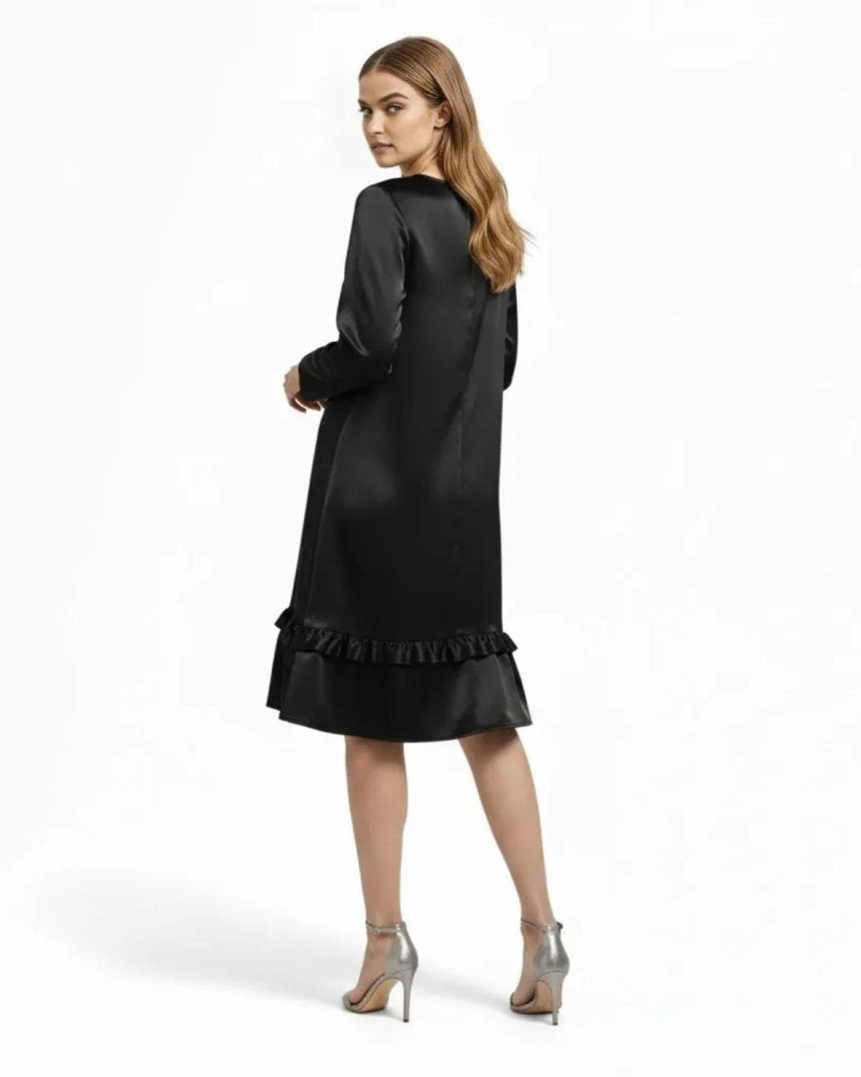  Back view of the Adalee minimalist little black dress showing its fluid drape and long sleeves.