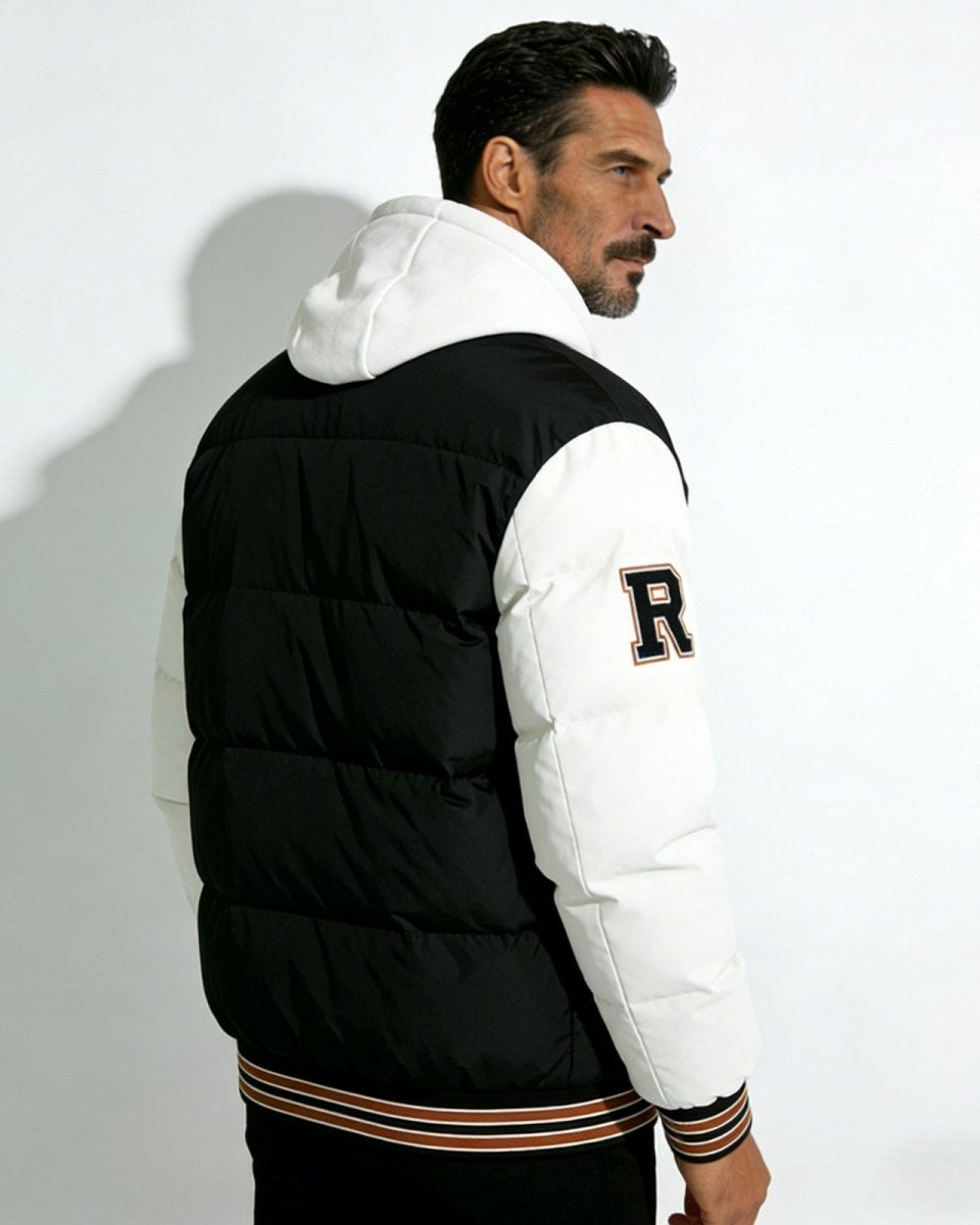 Back view of a man in the 'Angelo' varsity puffer jacket, highlighting the quilted black body, white sleeves, and white hood.