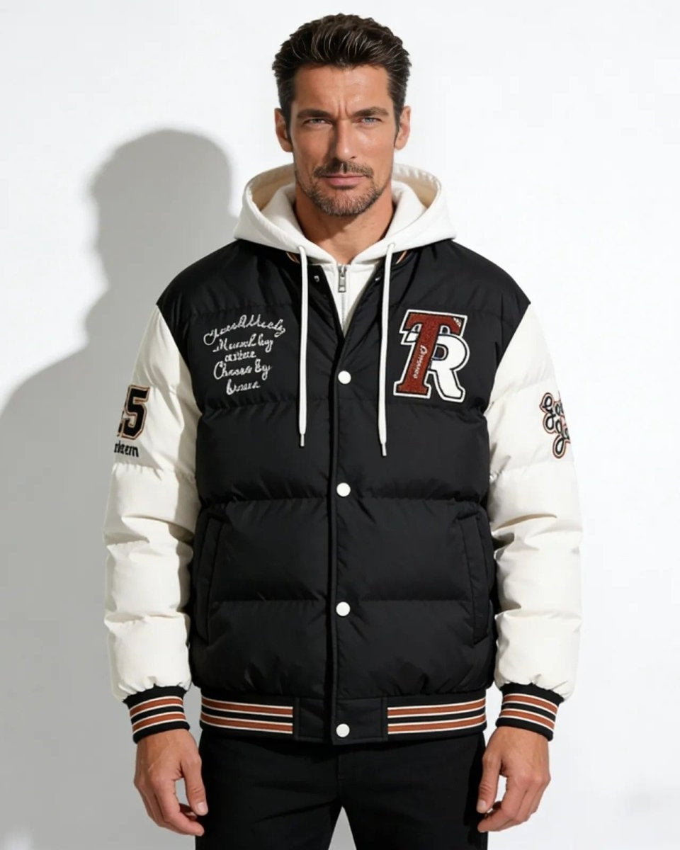Model wearing the 'Angelo' men's black hooded varsity puffer jacket, front view against a white background.
