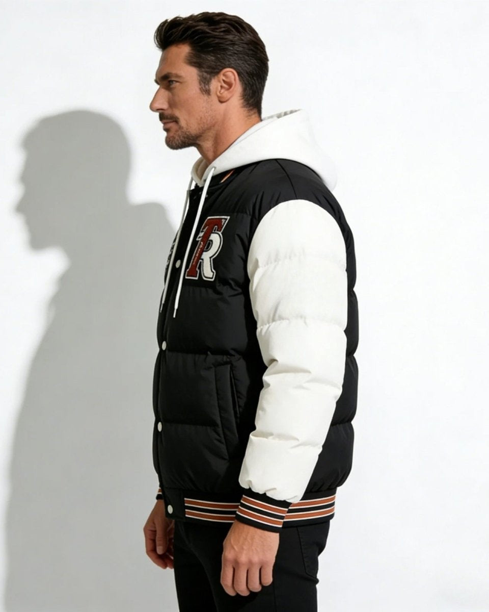 Side profile of a man wearing the 'Angelo' black and white varsity puffer, showing the embroidered 'R' and sleeve details.