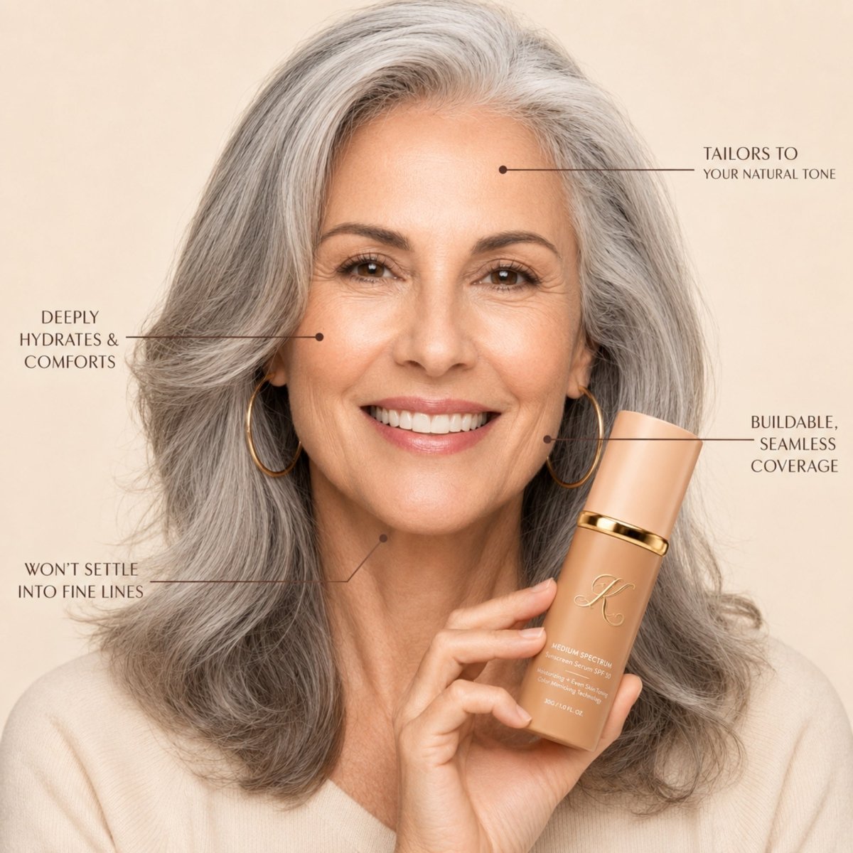 Smiling woman with silver hair holding Kouvr foundation with benefit callouts highlighting buildable seamless coverage that won't settle into fine lines.