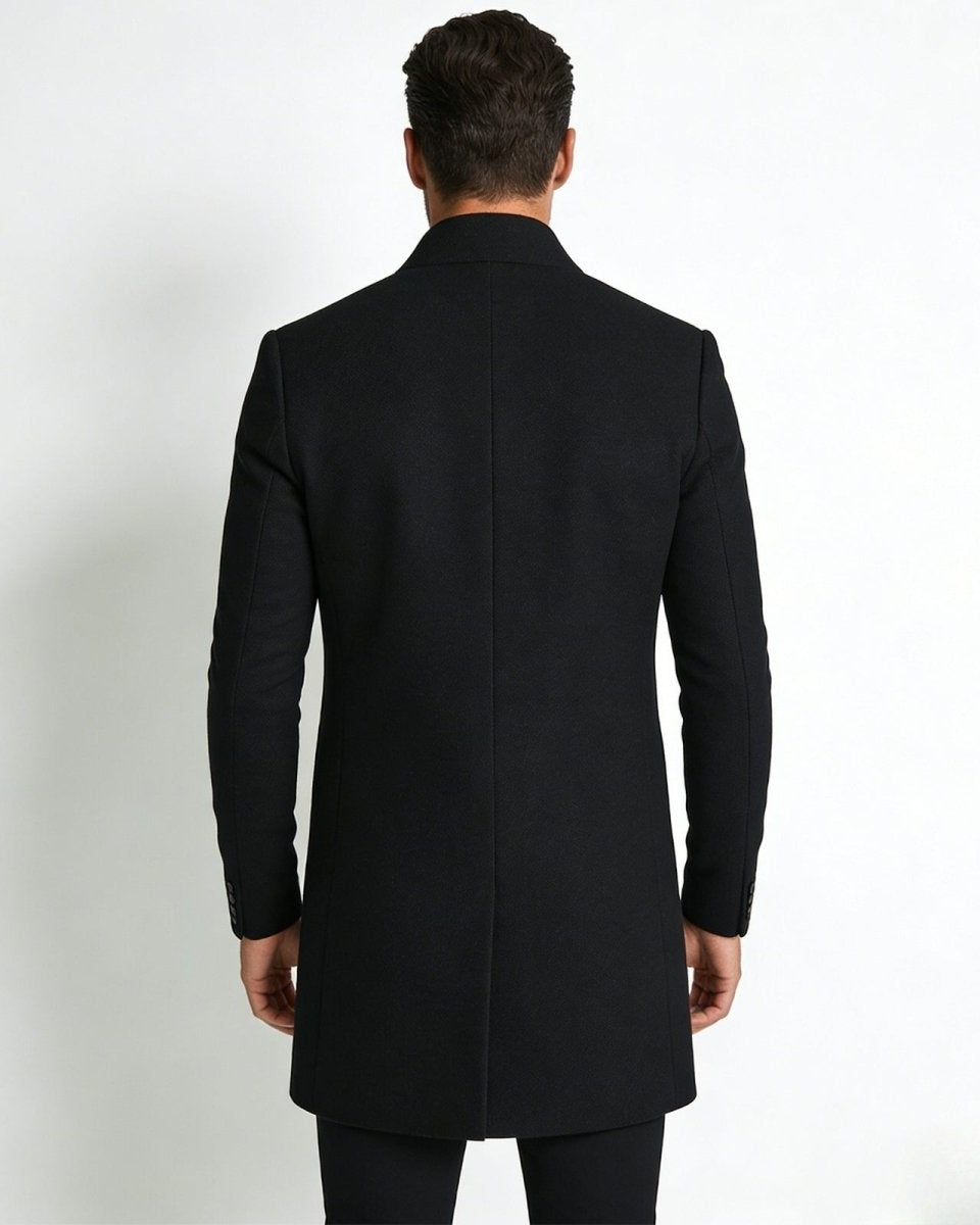 Back view of a male model wearing the  Archie black winter topcoat, highlighting the single back vent and structured shoulders.