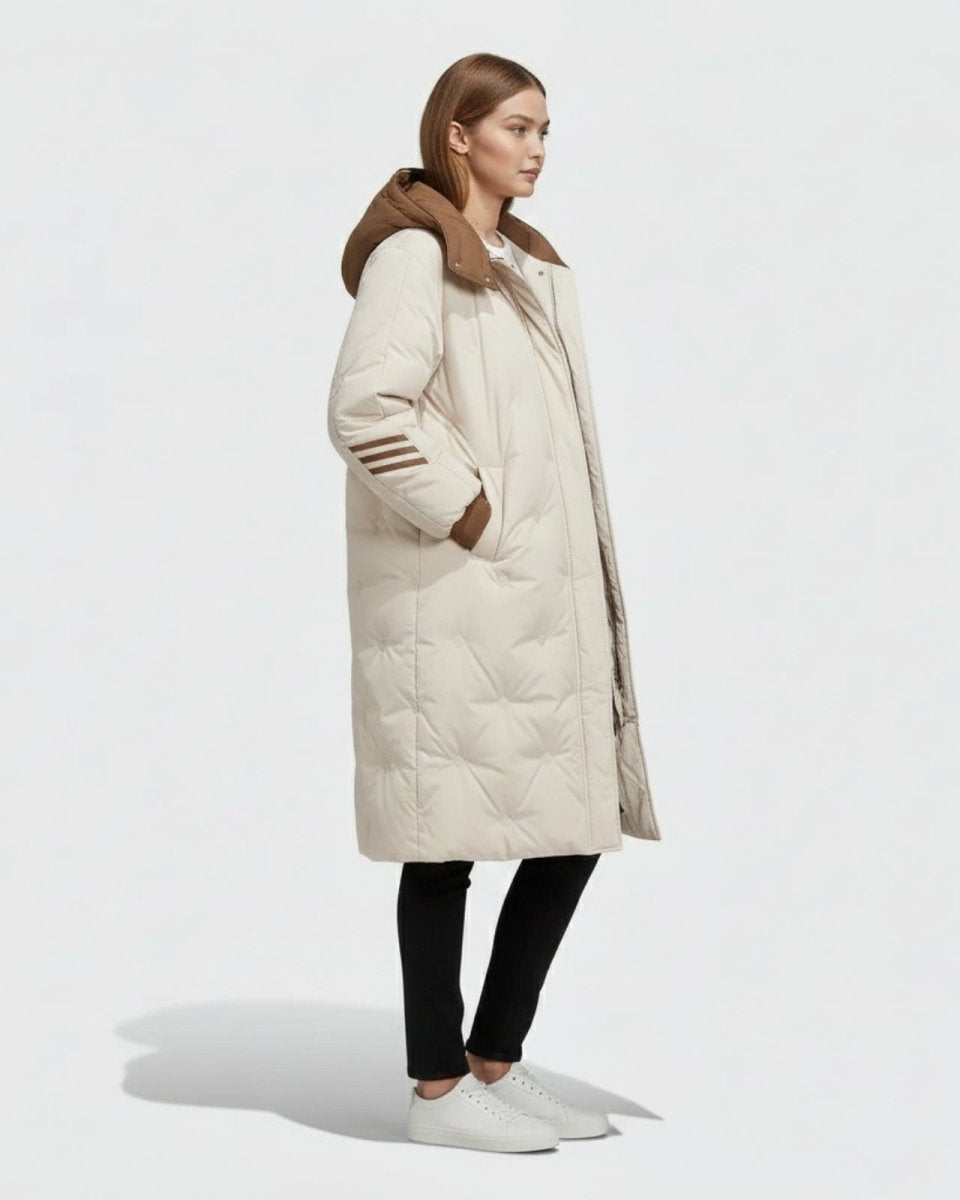 Side profile view of a woman wearing the Arianne oversized long down parka, showcasing its knee-length and quilted texture.