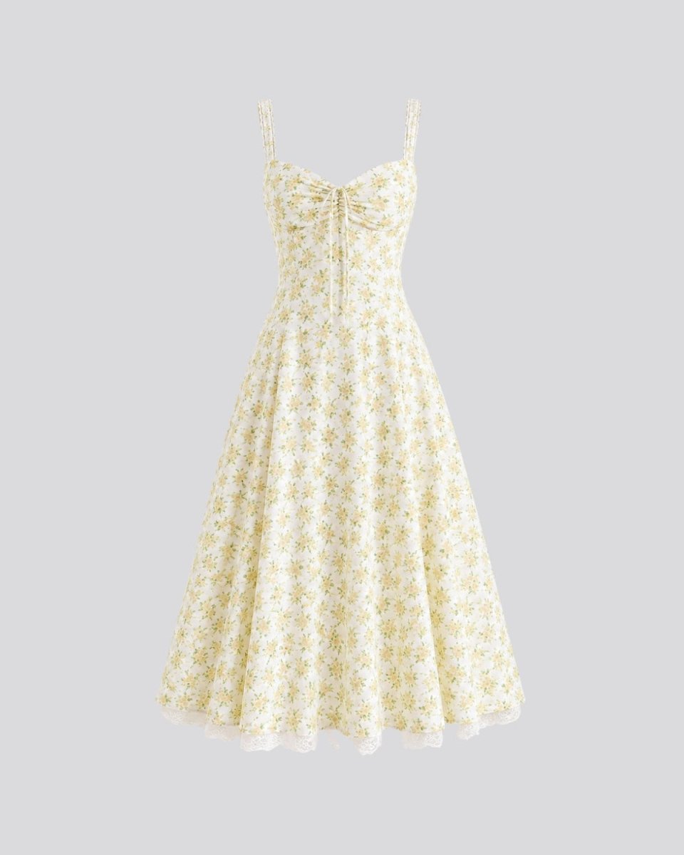 A sleeveless A-line midi dress with a small yellow and green floral print on a cream background, featuring a sweetheart neckline with a front bow detail and thin shoulder straps, shown against a solid gray background.