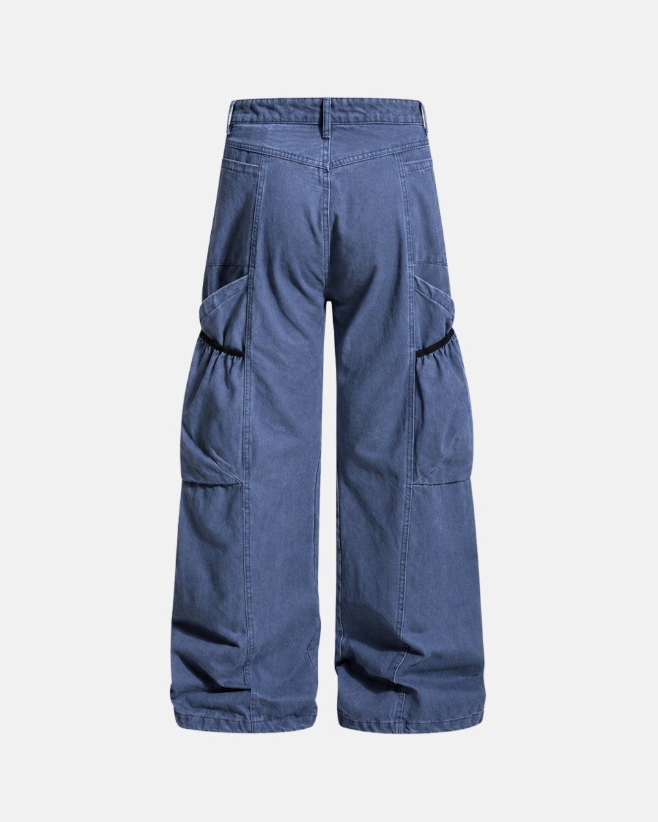A pair of wide-leg cargo pants in a medium blue denim-like fabric, shown from the back against a light gray background.