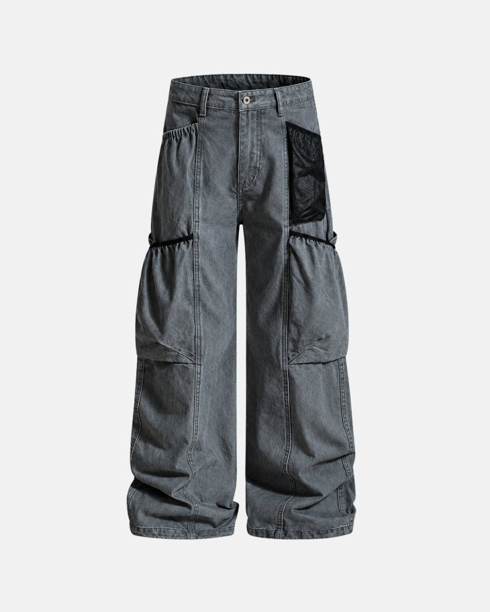 A pair of wide-leg cargo pants in washed dark gray denim, featuring a black mesh pocket on the right hip and black elasticized drawstring details on the left leg, shown against a light gray background.