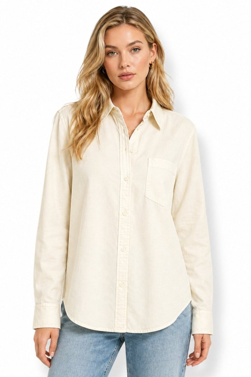Woman wearing a premium beige heavyweight cotton button-down shirt in a relaxed fit, paired with light blue jeans.