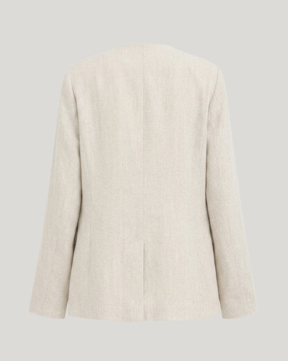 Flat lay ghost mannequin back view of a beige lightweight summer blazer showcasing seaming. 