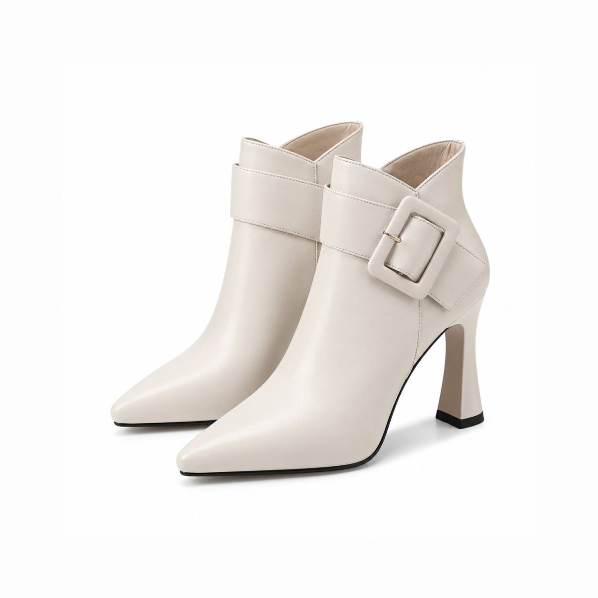 Close up of women's cream pointed toe ankle boots featuring an architectural flared heel and oversized buckle
