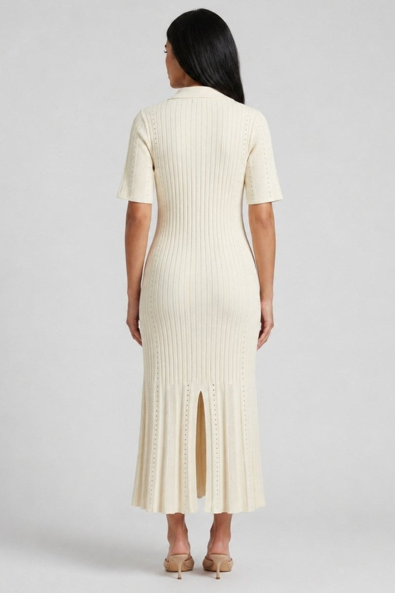 Back view of woman wearing Fenlo Form beige pointelle knit sweater dress showing back slit detail.