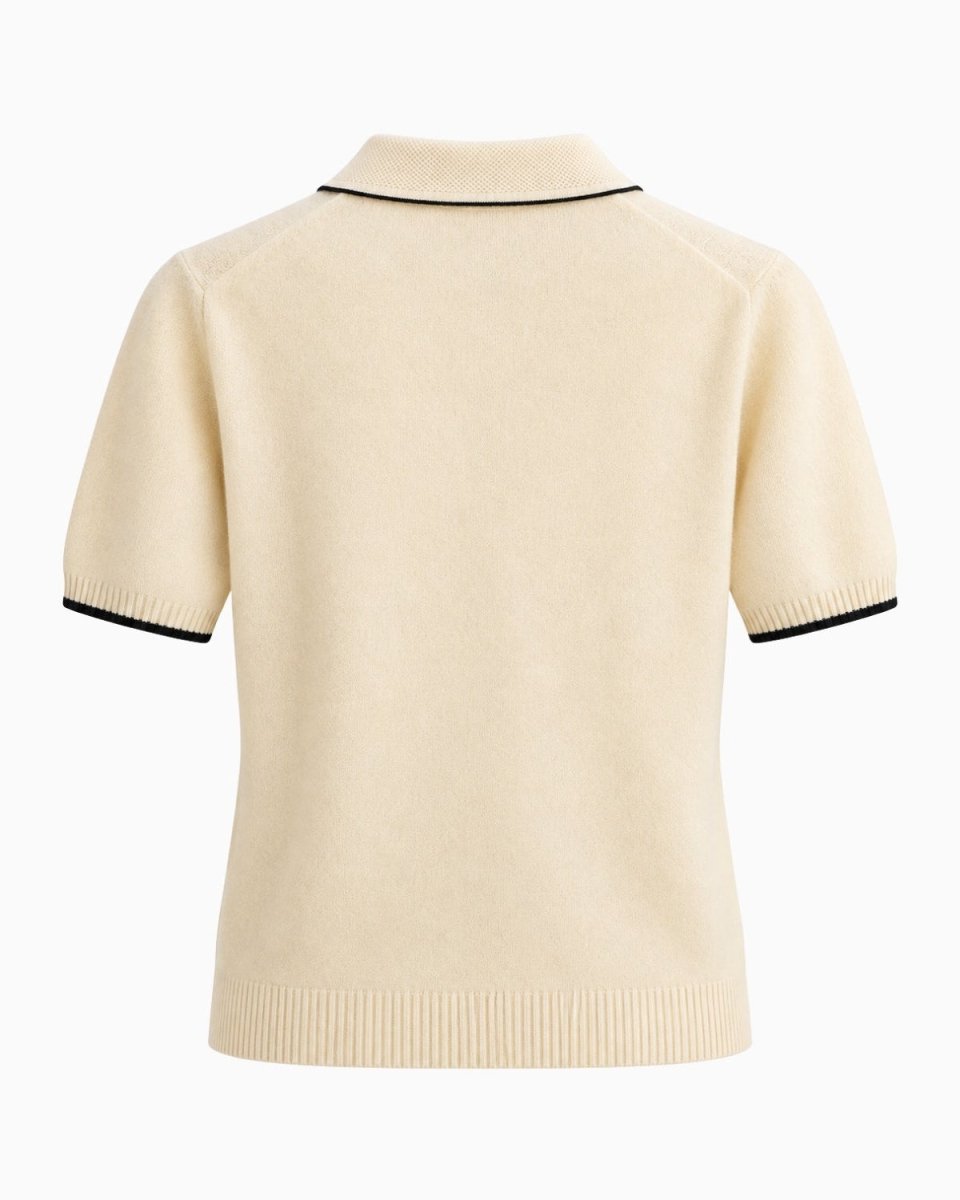 A beige-colored short-sleeve knit polo shirt shown from the back, featuring thin black piping trim along the collar and sleeve cuffs, set against a plain white background.