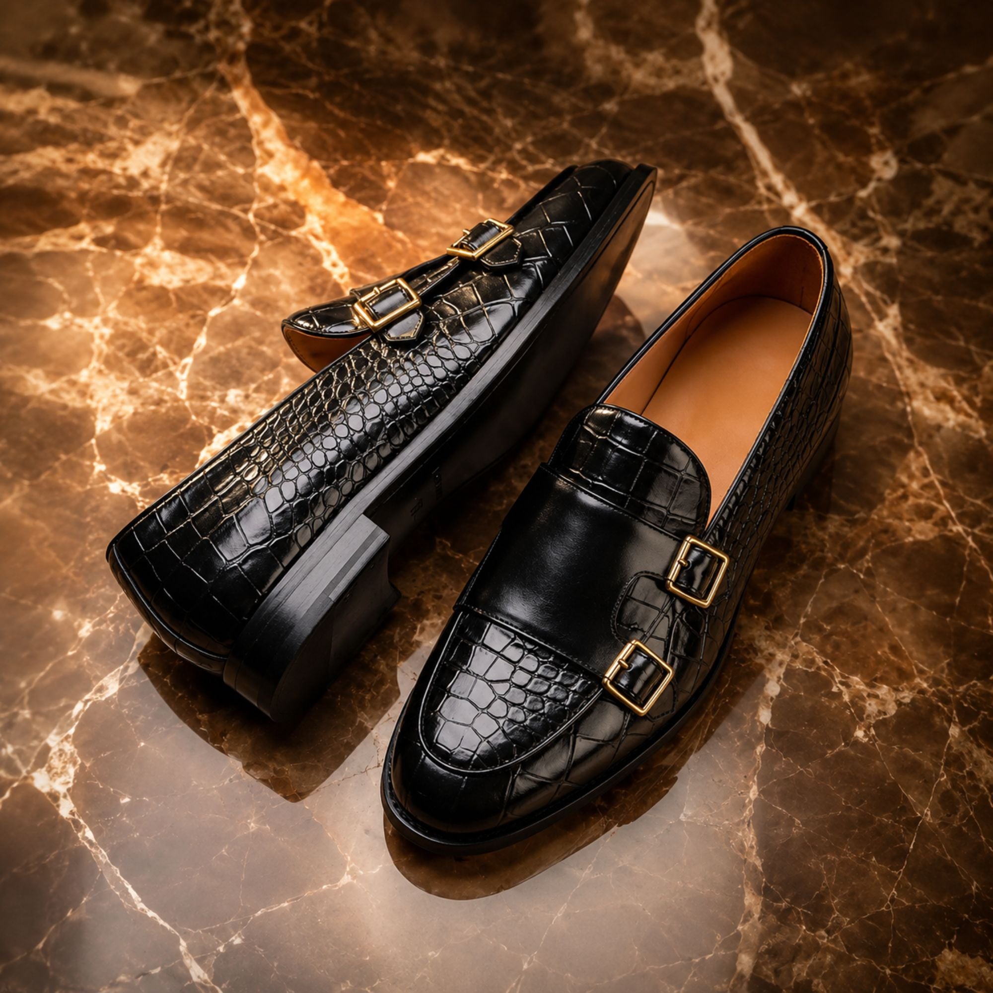 A pair of black double-strap loafers with mixed crocodile-embossed and smooth leather panels, displayed on a brown marble surface.