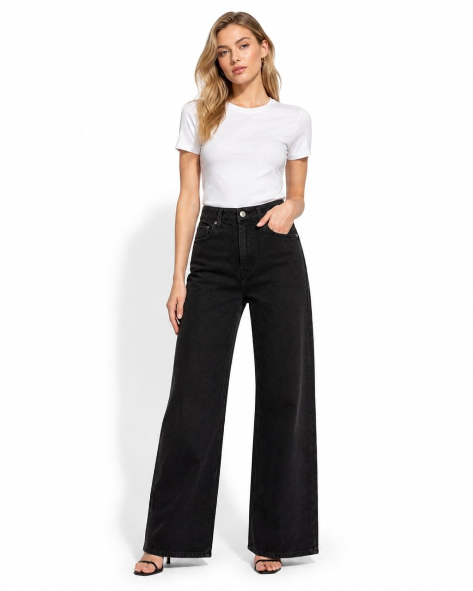 A woman modeling a white short-sleeve crewneck t-shirt and black wide-leg jeans against a plain white background.