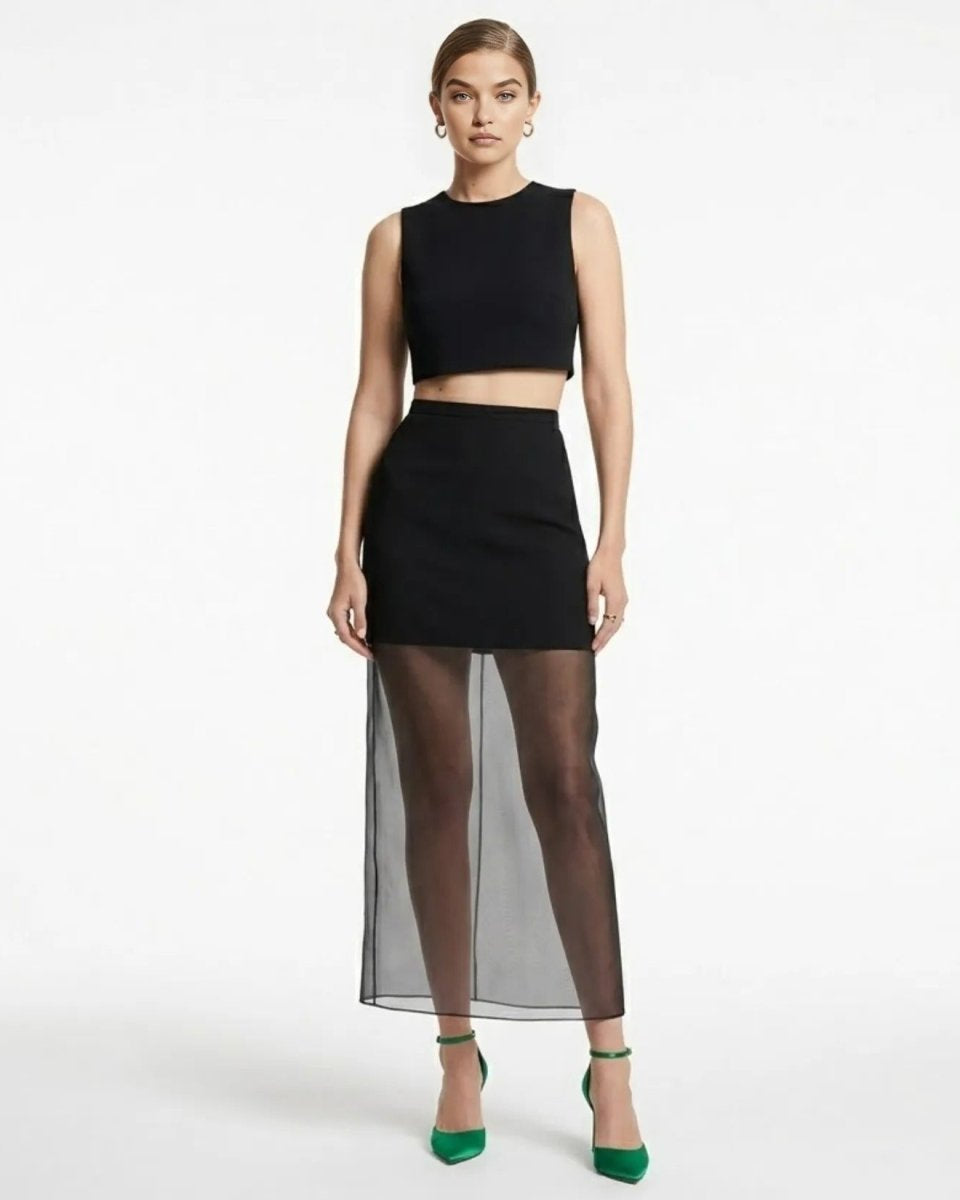 Full body studio shot of woman modeling affordable luxury black high waisted skirt with sheer organza maxi overlay