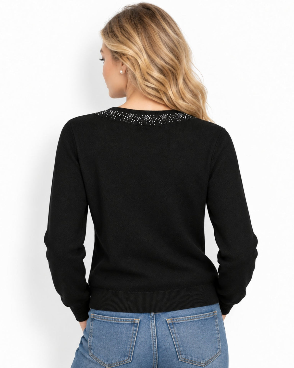 A woman viewed from the back wearing a black long-sleeve sweater with a decorative beaded neckline and blue jeans, set against a plain white background.