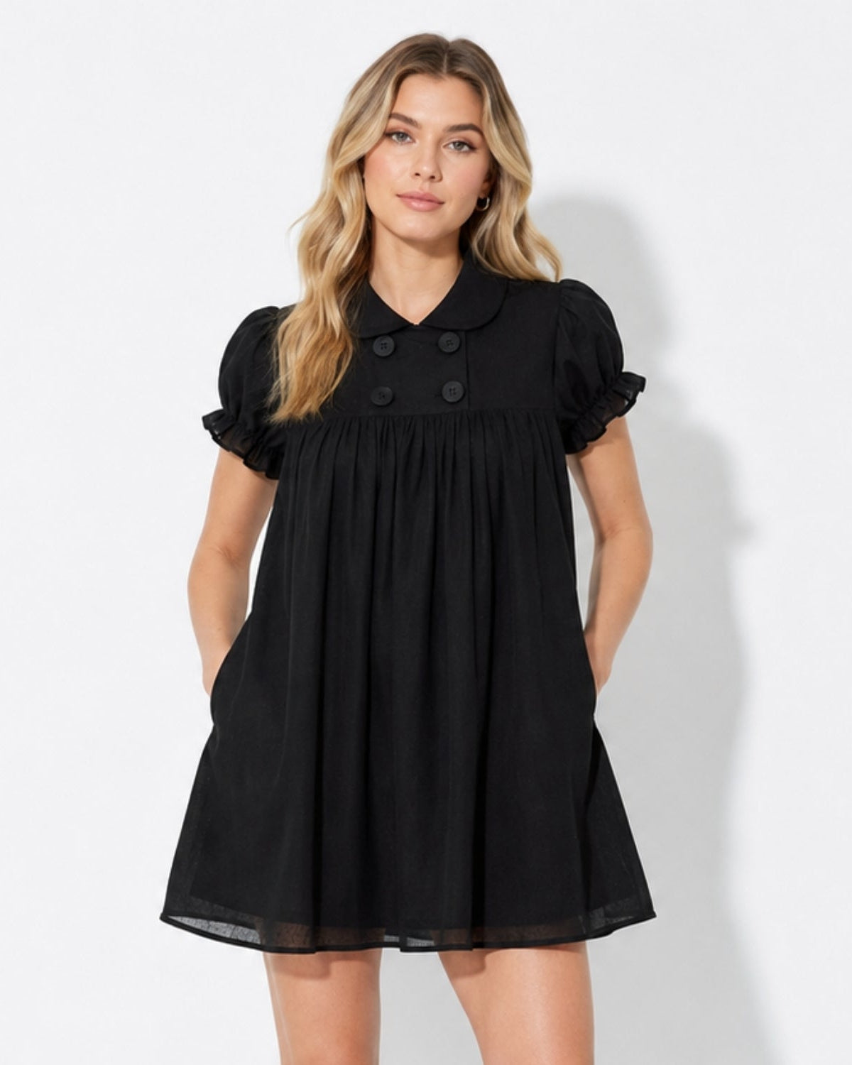 Front view of a woman wearing the luxury black puff sleeve babydoll mini