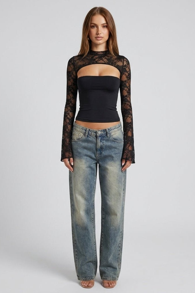 Full body look of a model wearing an elegant black lace long sleeve cutout top paired with vintage wash straight leg denim jeans.