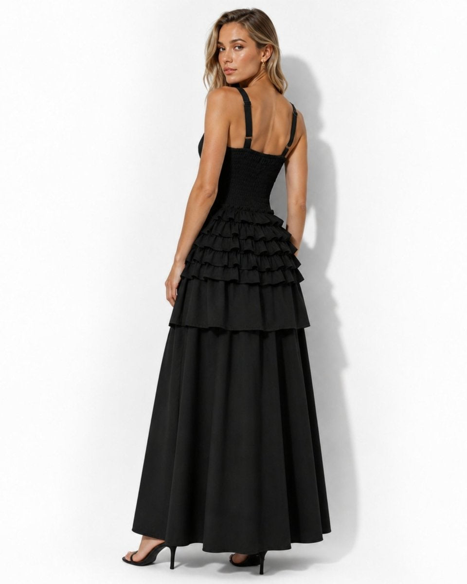 Back view highlighting the engineered smocked bodice and adjustable hardware straps on black elegant a-line midi dress.