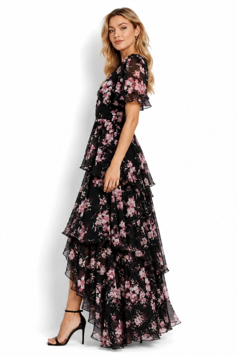 Side profile of elegant black floral ruffle maxi dress for wedding guests showing high low hemline