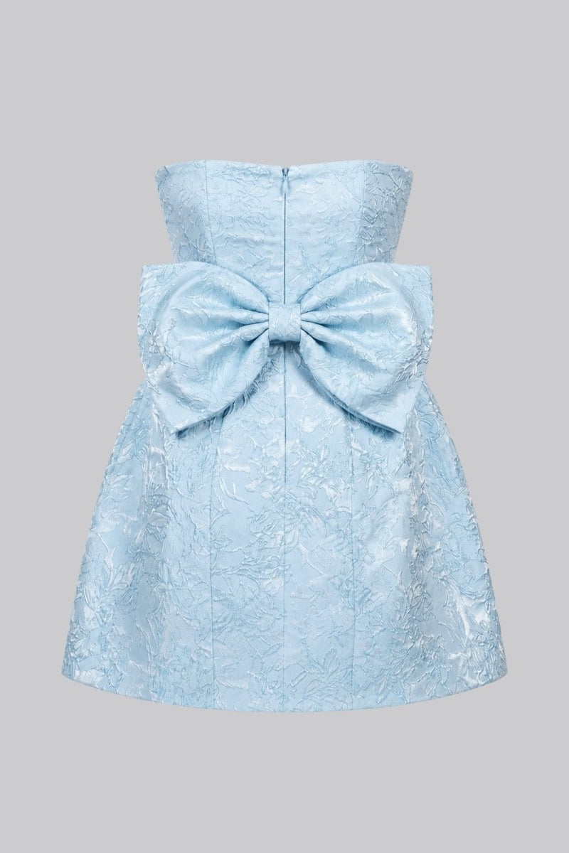 Flat lay back view of the light blue jacquard dress detailing the large structured statement bow and back zipper closure.