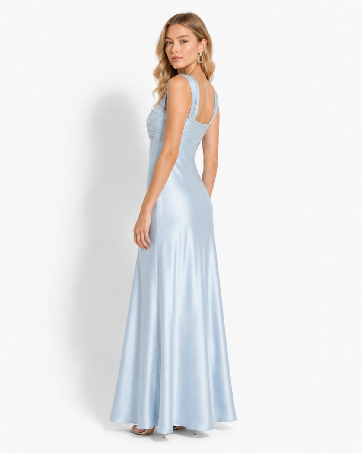 Side angle of ice blue luxury satin maxi dress highlighting the flowing drape and wide ruched shoulder straps