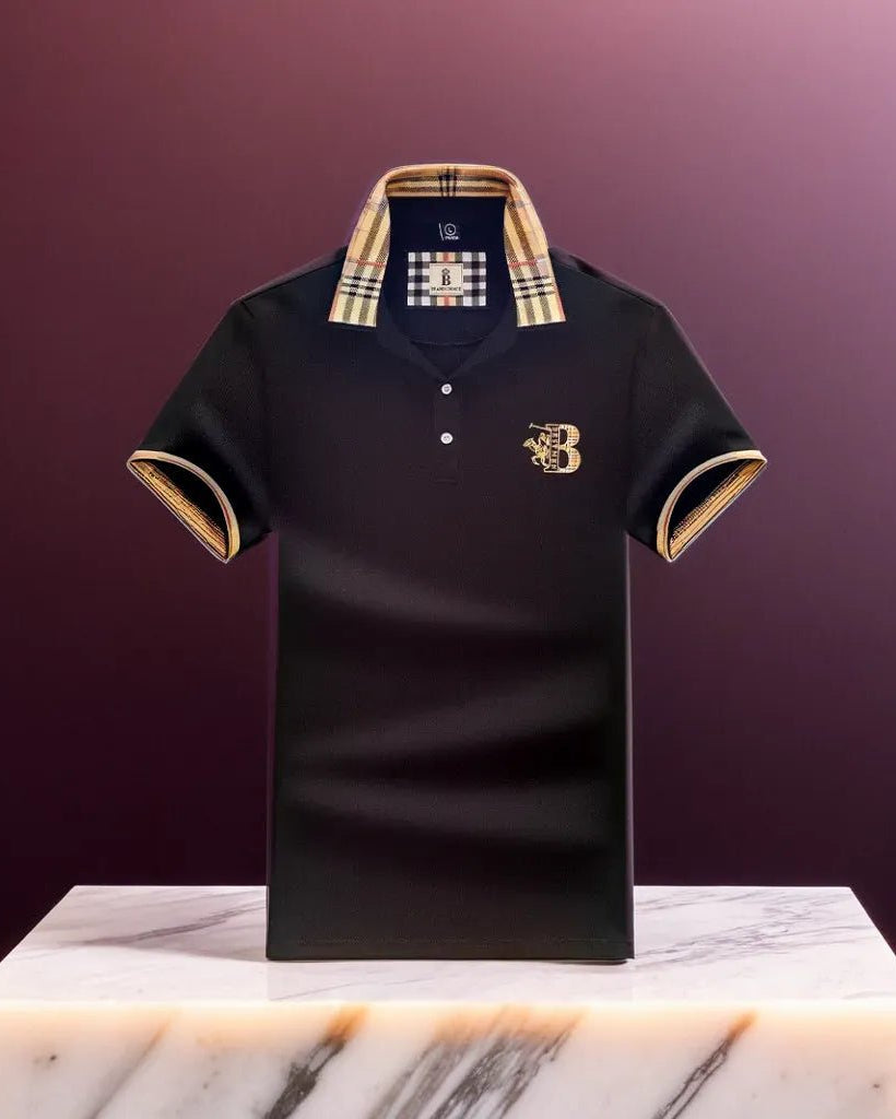 Black polo shirt with gold accents on a marble surface against a purple background
